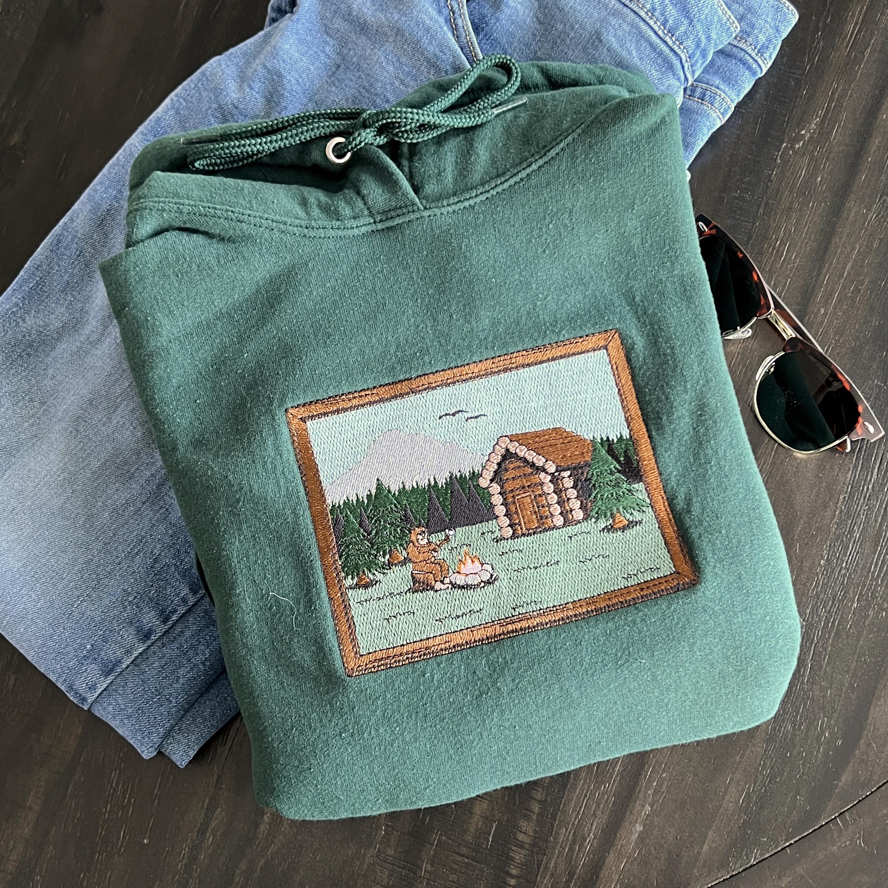 Sasquatch Log Cabin Scene Embroidered Hoodie Sweatshirt Unisex Camping Forest Mountains Long Sleeve Outdoors Personalized Multiple Colors Sasquatch Log Cabin Scene Embroidered Hoodie Sweatshirt Unisex Camping Forest Mountains Long Sleeve Outdoors Personalized Multiple Colors